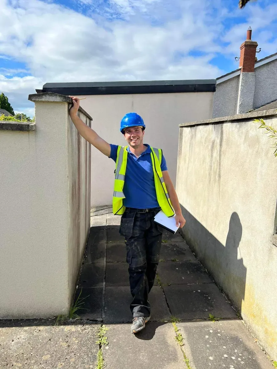 Temo, founder of Oisin Roofing & Guttering, in hi-vis on a Dublin roof